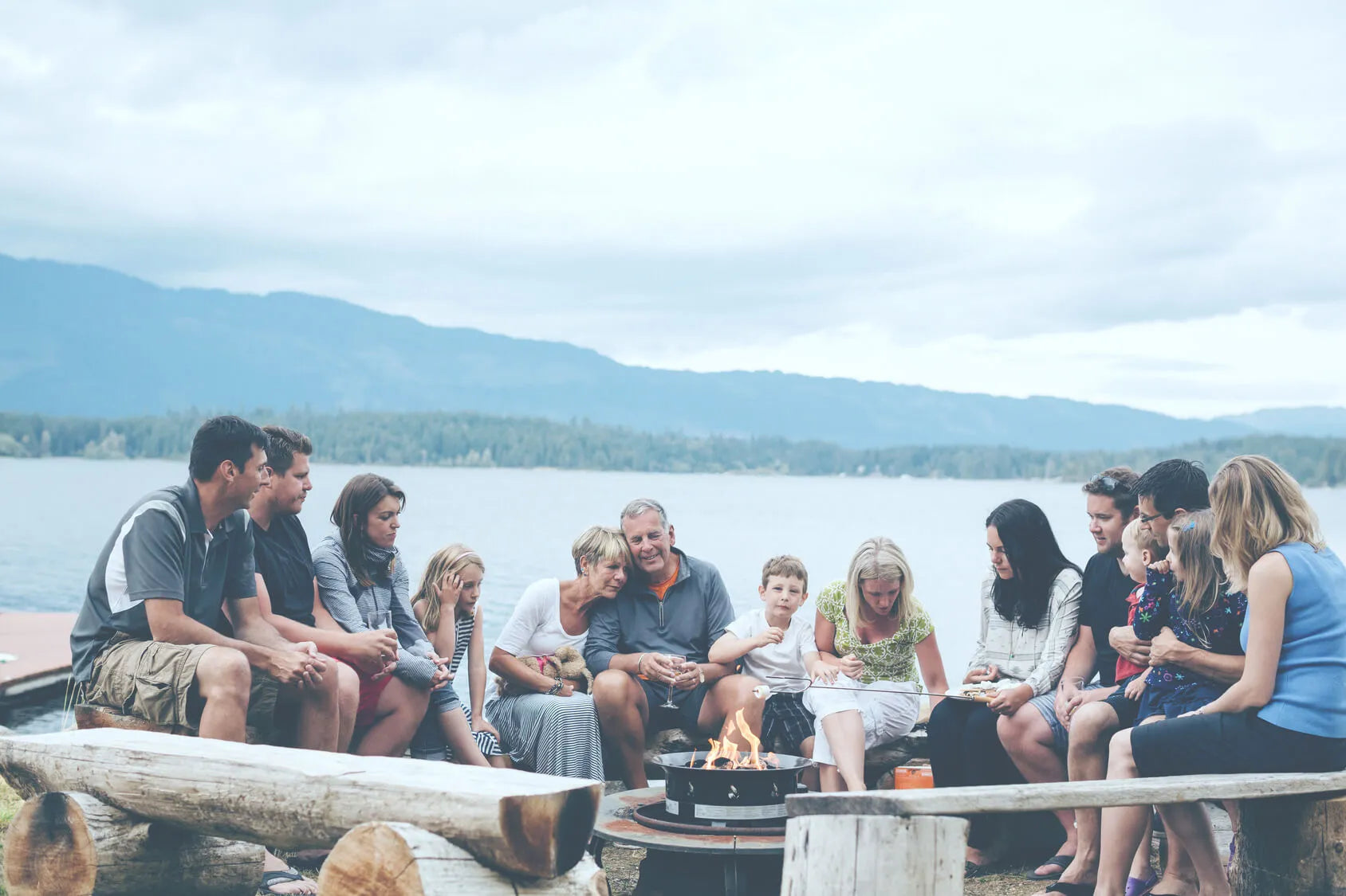 a large group of people together by a lake enjoying eachother's company